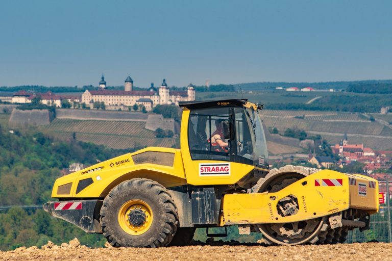 Bild: Baumaßnahmen in Heidingsfeld (STRABAG Bagger mit Festung Würzburg im Hintergrund), zeigt den Einsatz von Baumaschinen und die Festung Würzburg als Hintergrundkulisse während der Bauarbeiten in Heidingsfeld.